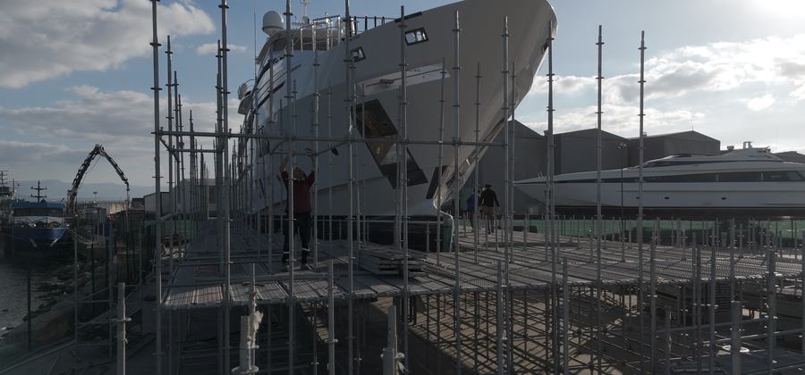 Motor yacht surrounded by scaffolding during a refit