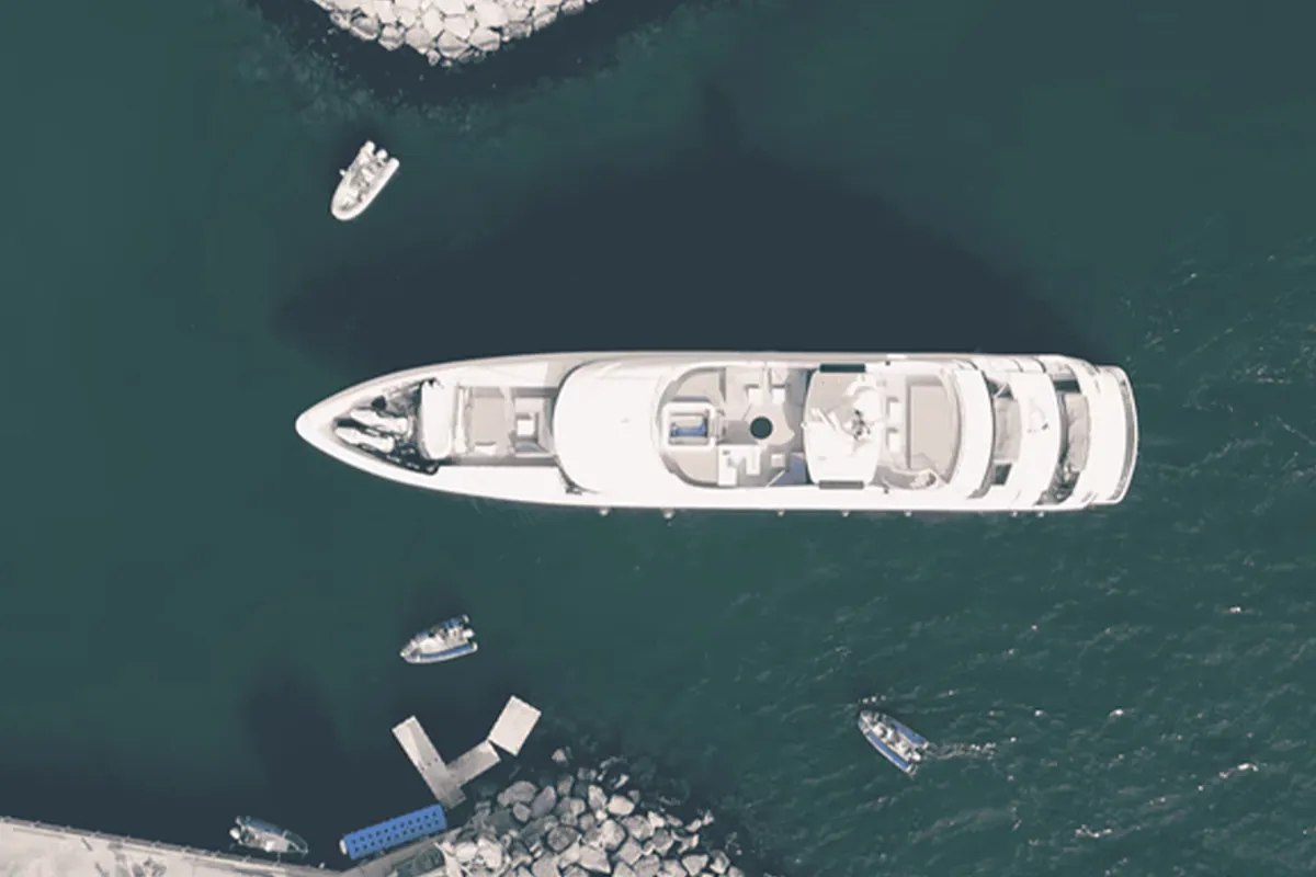 Motor yacht and support boats passing between the marina breakwaters