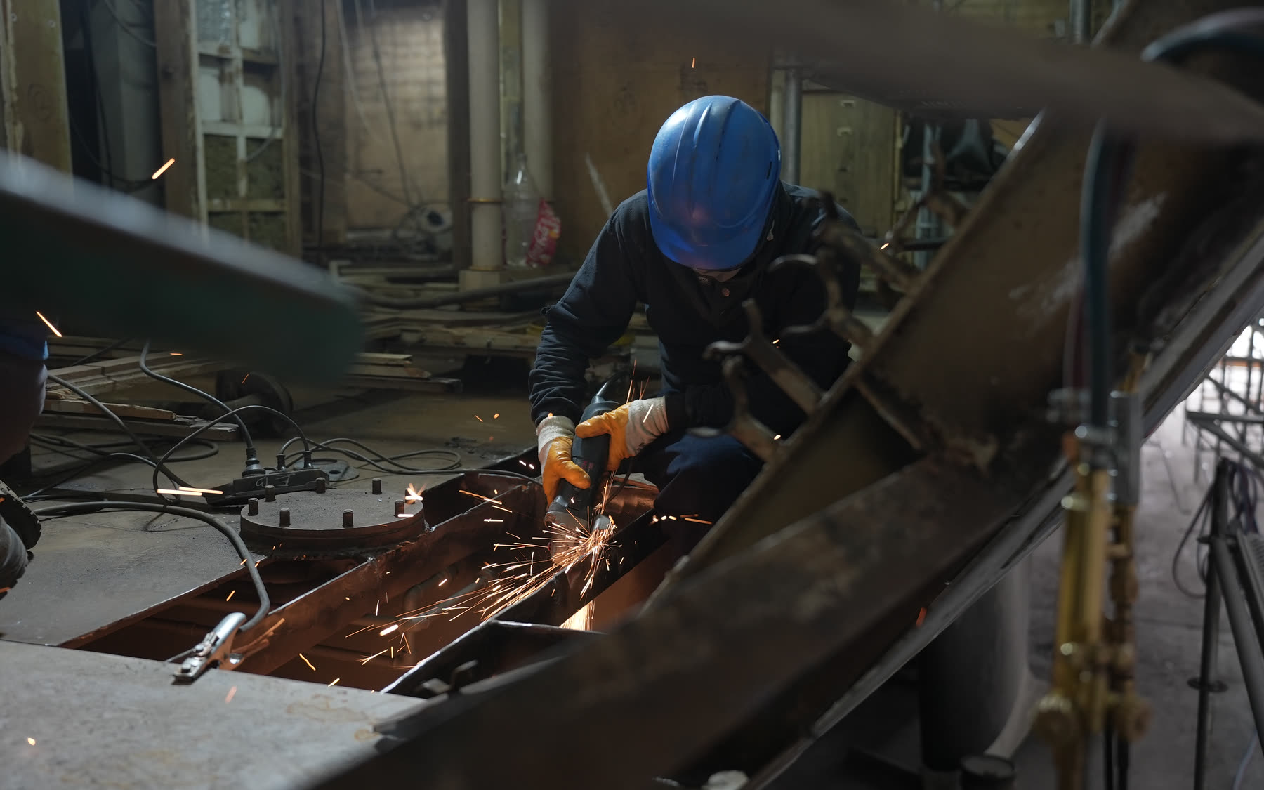 Yard specialist grinding steel during refit work