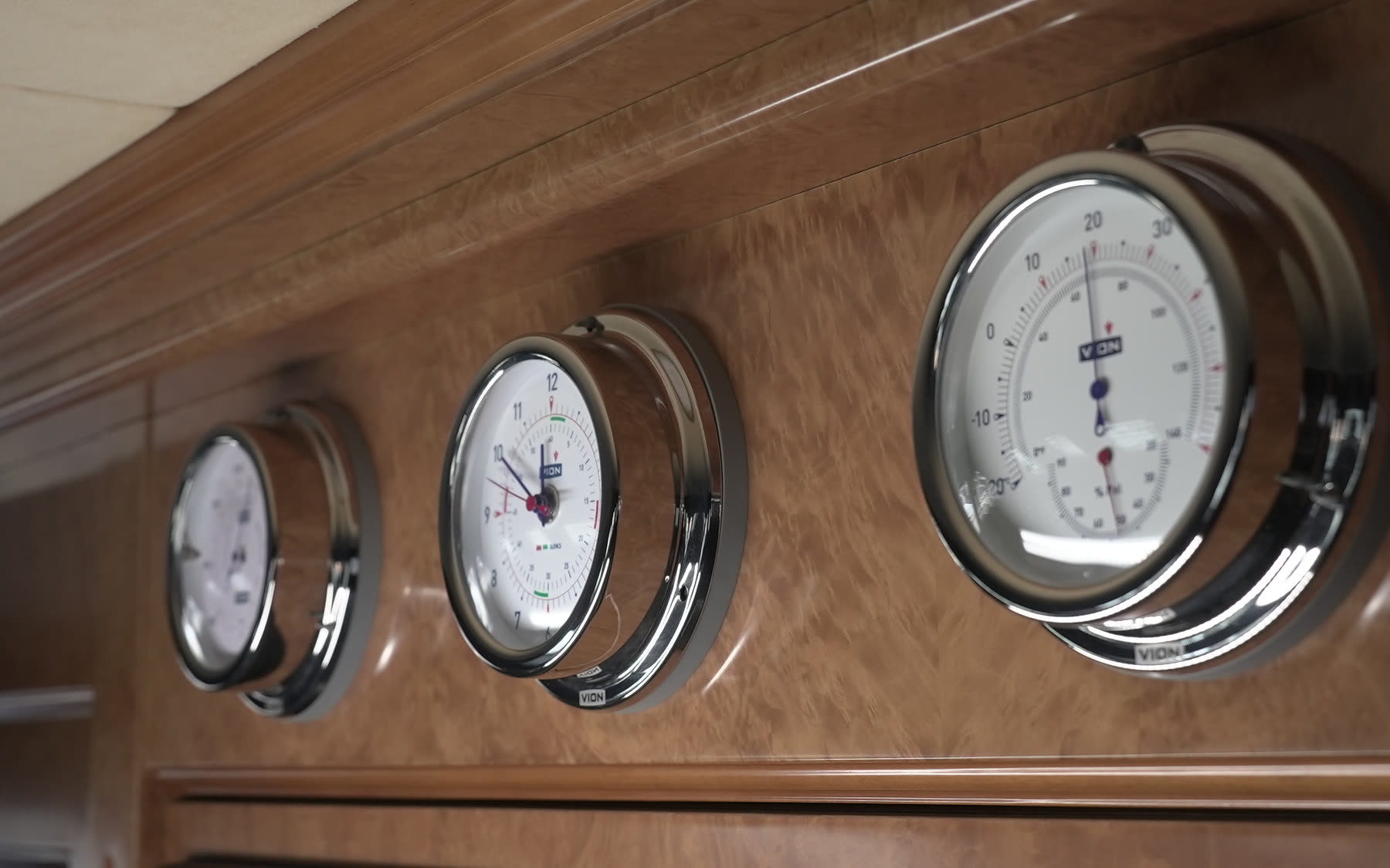 Three analogue gauges mounted on a yacht interior panel