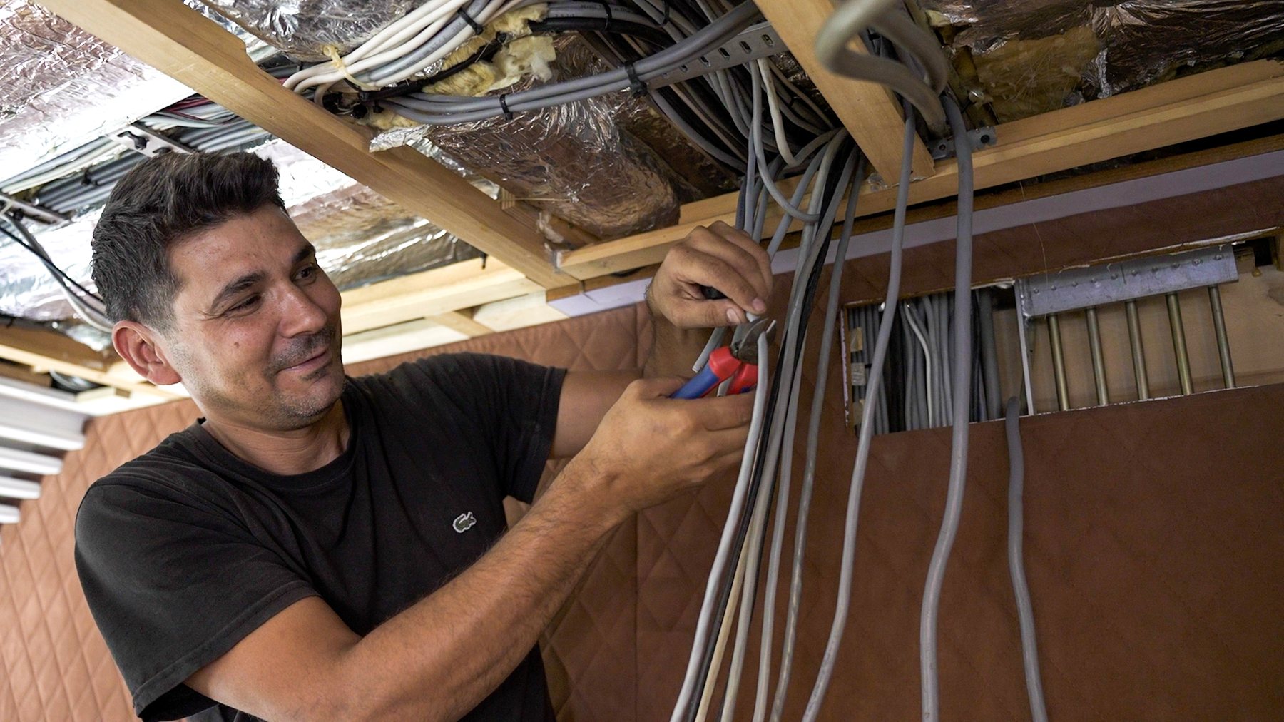 Specialist working on cable runs inside a motor yacht